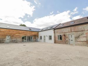 an empty parking lot in front of two buildings at Threshing Barn in Blandford Forum
