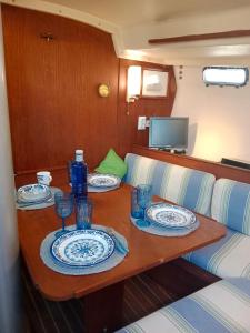 una mesa con platos y vasos en un barco en Velero Valencia Whimsy en Valencia