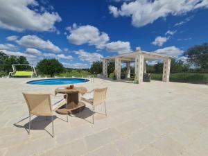 a patio with a table and chairs next to a pool at Casa Loredana in Putignano