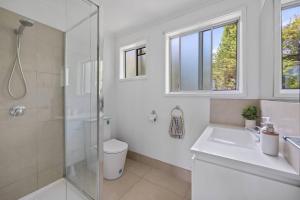 a bathroom with a shower and a toilet and a sink at Prom Coast - Seabreeze in Sandy Point +83 photos
