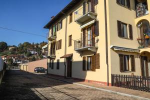 un bâtiment jaune avec un balcon et une rue dans l'établissement La Dimora di Nonno Piero, à Manta