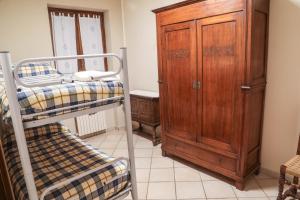 La Dimora di Nonno Piero في Manta: غرفة نوم مع سرير بطابقين وخزانة خشبية