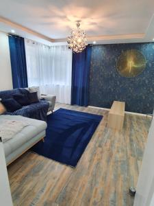ein Wohnzimmer mit einem Sofa und einem Kronleuchter in der Unterkunft Escale Marine Basel Airport in Hésingue