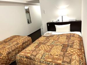 a hotel room with two beds in a room at Hotel Tokeidai in Sapporo