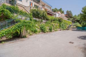una calle vacía delante de un edificio con hiedra en Le terrazze di Acciaroli - Happy Rentals, en Acciaroli