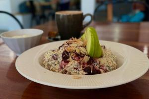 a white plate of food on a wooden table at Aloha Rainbow Beach in Rainbow Beach