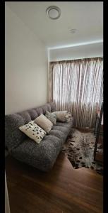 uma sala de estar com um sofá com almofadas em Rare GEM in Westgate em Auckland