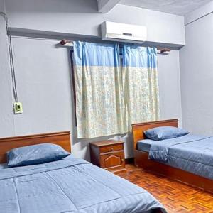 um pequeno quarto com 2 camas e uma janela em Saysouly Guest House em Ban Nongdouang