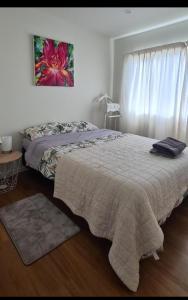 1 dormitorio con 1 cama y una pintura en la pared en Rare GEM in Westgate en Auckland