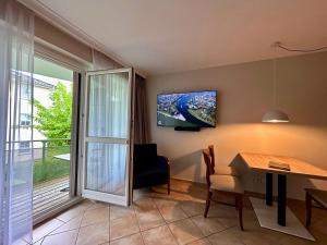 a living room with a table and a tv on the wall at Ferienwohnung „mittendrin“ in Zinnowitz