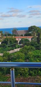 uma varanda com vista para as árvores e para o oceano em Nyali Luxury em Mombaça