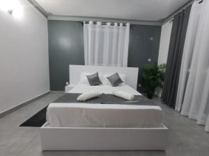 uma cama branca num quarto com cortinas brancas em Nyali Luxury em Mombaça