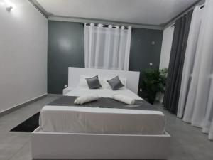 uma grande cama branca num quarto com cortinas brancas em Nyali Luxury em Mombaça