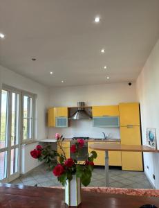 een keuken met gele en blauwe kasten en een tafel bij Villa Fiore in Nettuno