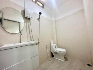 uma casa de banho com um WC branco e um espelho. em Oh'lala Bungalow em Ko Phangan