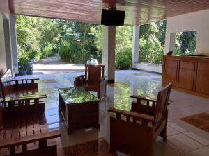 ein Esszimmer mit einem Glastisch und Stühlen sowie einem großen Fenster in der Unterkunft Hôtel La Belle Etoile in Labuan Bajo