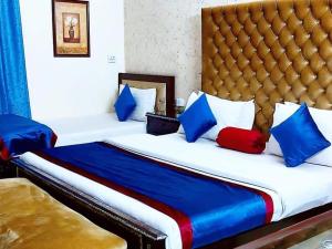 um quarto com 2 camas com almofadas azuis e vermelhas em Calming Residence em Lahore