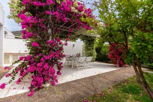 a bunch of pink flowers on a tree in a yard at Villa Buganvillea near the beach in Maracalagonis