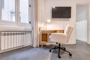 um quarto com uma secretária, uma cadeira e uma televisão em Apartamento Retiro Place II en Madrid em Madri