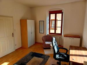 una camera con una sedia, un tavolo e una finestra di Wachau - Angenehm ruhiges Zimmer 6 a Mautern an der Donau