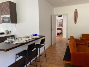 cocina y sala de estar con barra y sillas en THE BEACH - large apartment with private beach, en Pettenasco