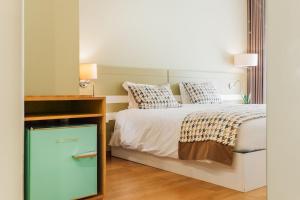 Un dormitorio con una cama y un tocador al lado. en Alva Valley Hotel, en Oliveira do Hospital