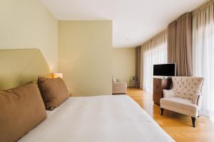 une chambre d'hôtel avec un lit et une chaise dans l'établissement Alva Valley Hotel, à Oliveira do Hospital