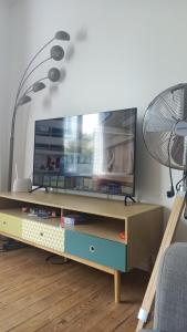 sala de estar con mesa y TV en Villa des Roses : Maison 3 chambres au calme, 7 pers, wifi, en Le Havre