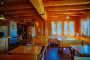 a dining room with tables and chairs and windows at Glatzl Trahütten Alm in Sankt Lorenzen am Wechsel