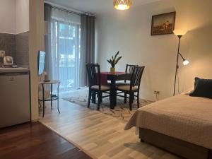 una camera con letto, tavolo e sedie di Apartament Łagiewniki Krakow a Cracovia