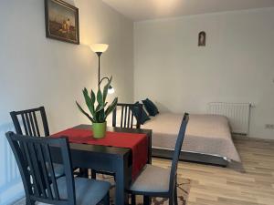 una sala da pranzo con tavolo e letto di Apartament Łagiewniki Krakow a Cracovia