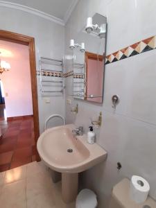 Baño blanco con lavabo y espejo en VIVIENDA VACACIONAL LA RITANA, en Sardalla
