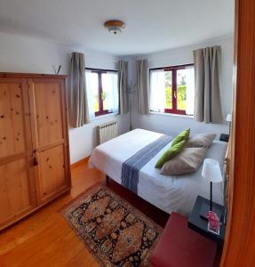 Un dormitorio con una cama con almohadas verdes. en VIVIENDA VACACIONAL LA RITANA, en Sardalla