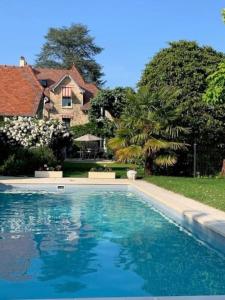 a large swimming pool in front of a house at Charmant Studio refait à neuf in Bois-le-Roi