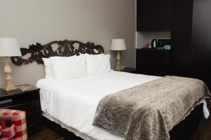 1 dormitorio con 1 cama blanca grande con almohadas blancas en Oaklands inn and Conference Centre, en Johannesburgo