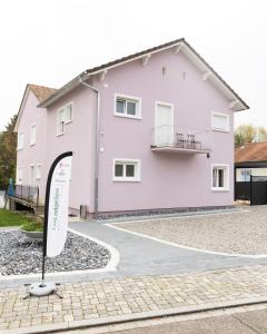 une maison rose avec un panneau devant elle dans l'établissement Loft Near Basel Airport, à Hésingue