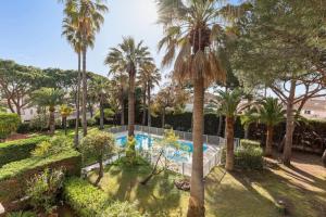 einen Pool in einem Park mit Palmen in der Unterkunft La vie est Gabelle in Vallauris