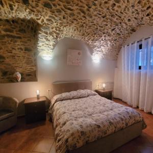 La Casa sull' Altopiano Mountain Lake Iseo hospitality في Bossico: غرفة نوم بسرير وجدار حجري