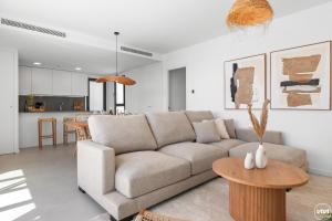 un soggiorno con un divano e un tavolo di Penthouse Diamond - Private Pool, Terrace, Sea View, Gym & BBQ a Las Lagunas Mijas