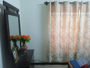 a mirror and a vase with flowers on a table at Family guest house in Rawalpindi