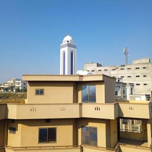 a building with a clock tower in the background at Family guest house in Rawalpindi