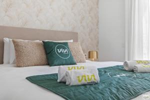 un letto con coperta verde e cuscini sopra di Penthouse Diamond - Private Pool, Terrace, Sea View, Gym & BBQ a Las Lagunas Mijas