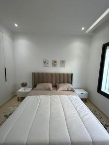 duże białe łóżko w białej sypialni w obiekcie joli appartement a jardin de Carthage w mieście Tunis