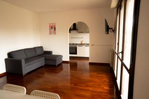 a living room with a couch and a kitchen at Ermete Eur House in Rome