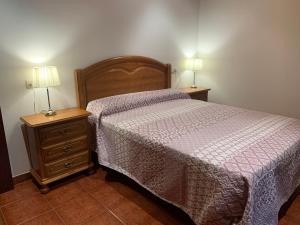 A Debesa do Rei في Lousame: غرفة نوم مع سرير وطاولة مع مصباحين