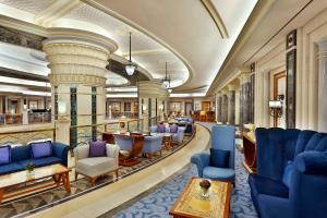 a hotel lobby with blue chairs and tables at The Ritz-Carlton Jeddah in Jeddah