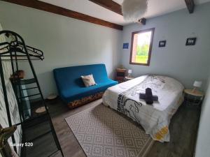1 dormitorio con 1 cama y 1 silla azul en Grand Gite ideal pour famille 10 personnes , 3chambres , 10 couchages en Criquiers