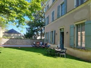 a yard with chairs and a table in front of a building at Grande maison familiale plein centre vieux Laval in Laval