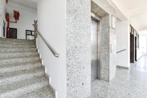 a staircase in a building with white walls and concrete floors at FabHotel KRB Paradise in Dehradun