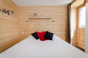 Cette chambre en bois comprend un lit blanc. dans l'établissement Chalet Epilobe - pied des pistes - vue magnifique, à Montvalezan